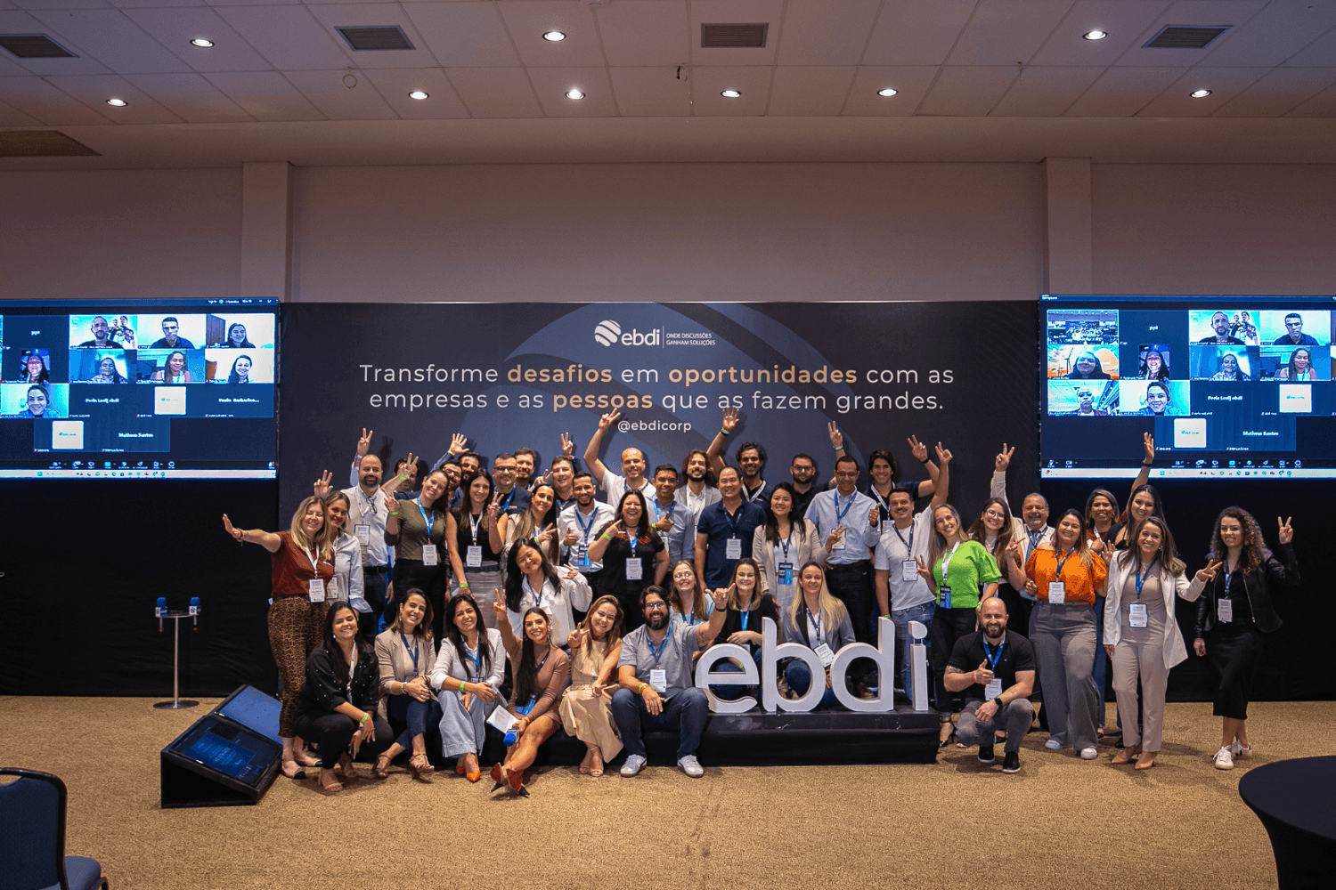 pessoas participantes do evento de EBDI reunidas e posando para a foto em um palco