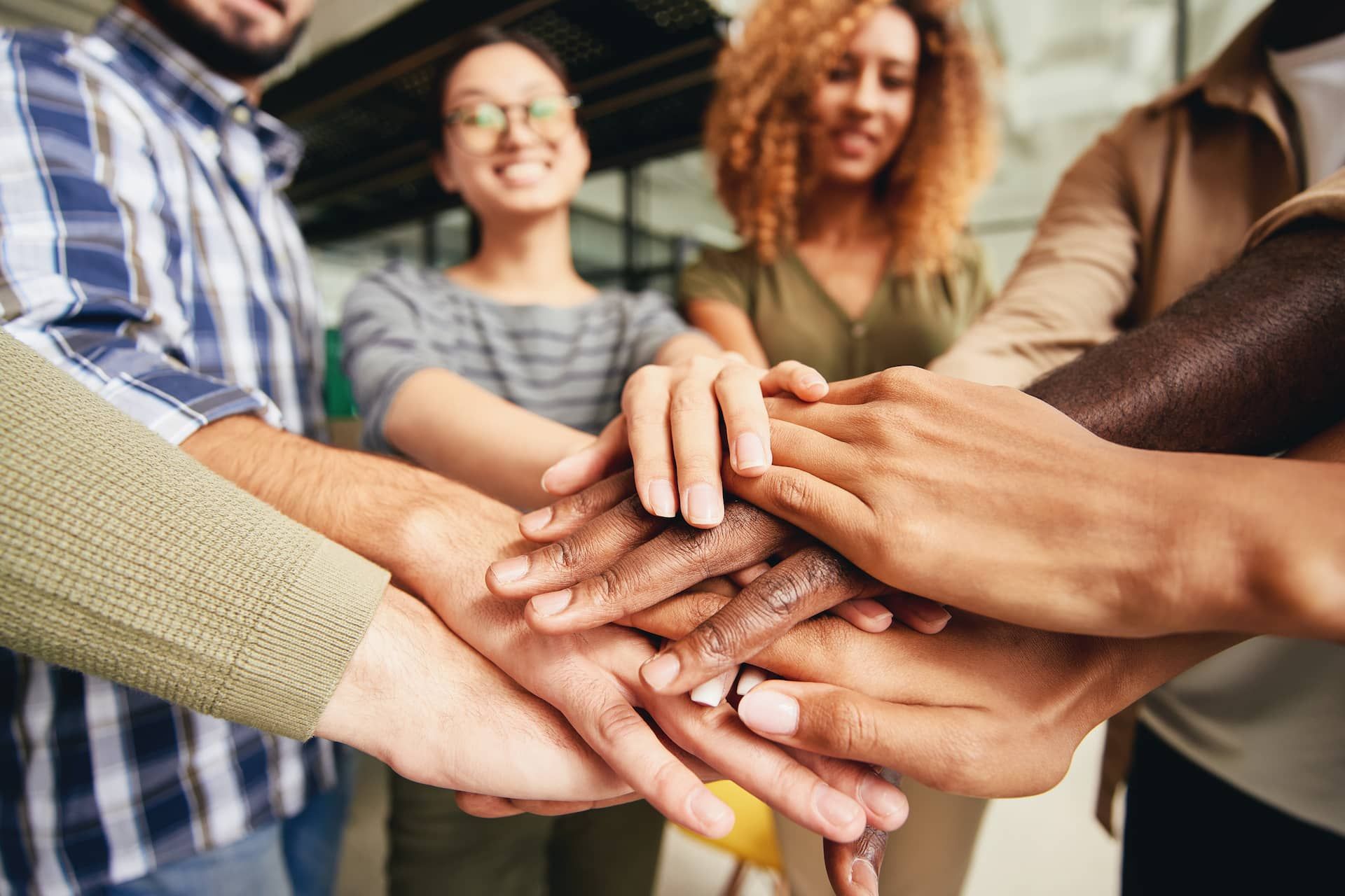 Grupo de pessoas com as mãos uma em cima das outras.