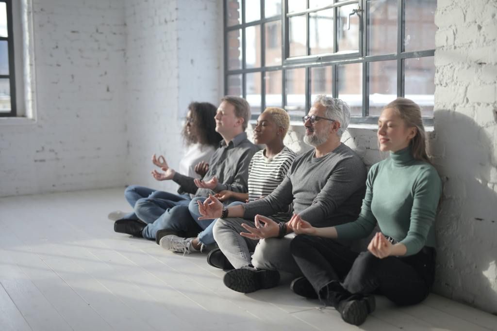 Funcionários de uma empresa meditando durante suas pausas no trabalho.